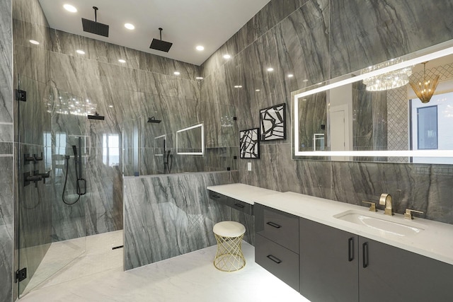 bathroom with vanity, tiled shower, and tile walls