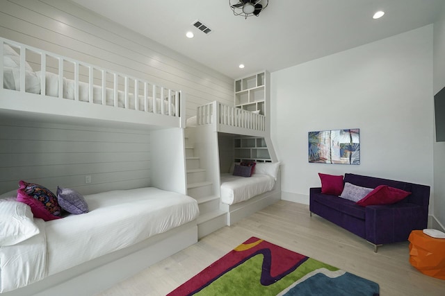 bedroom featuring wooden walls and light wood-type flooring