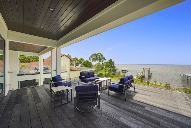 wooden deck with a water view and outdoor lounge area