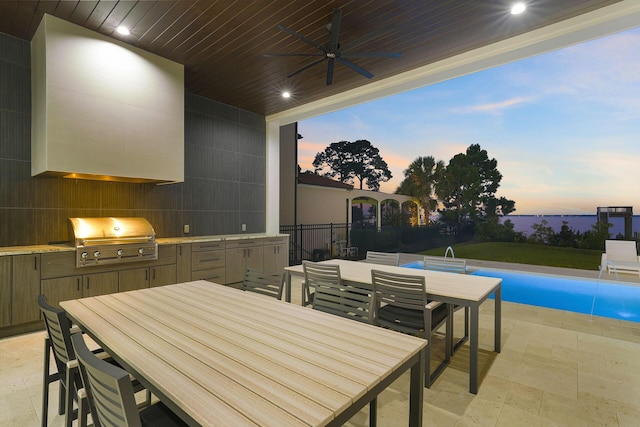 patio terrace at dusk with a fenced in pool, area for grilling, a grill, and ceiling fan