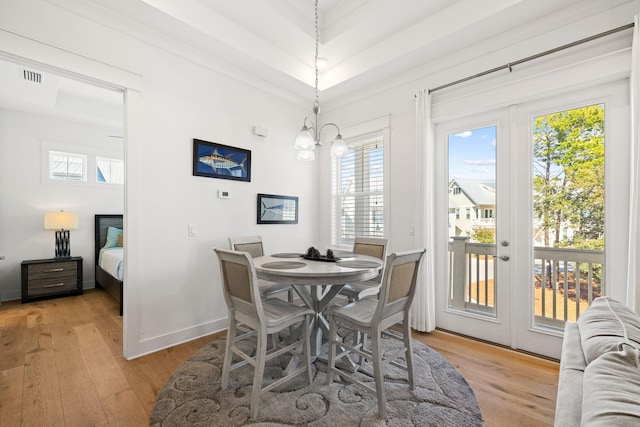 dining space featuring a notable chandelier, light hardwood / wood-style floors, and french doors