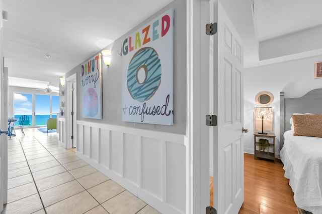 hallway with a water view and light hardwood / wood-style flooring