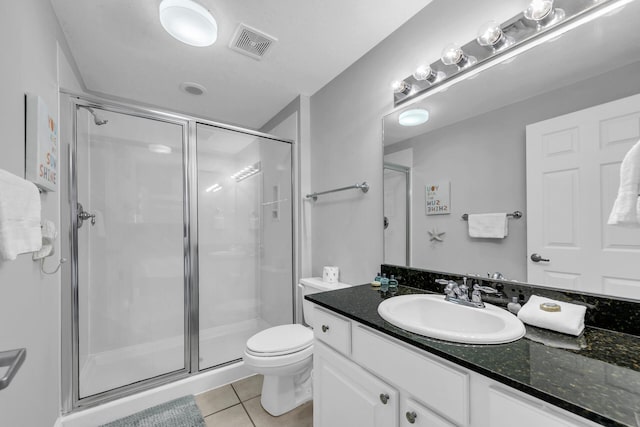 bathroom with vanity, tile patterned floors, toilet, and walk in shower