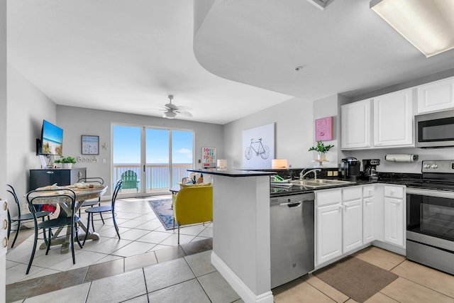 kitchen with sink, stainless steel appliances, kitchen peninsula, and white cabinets