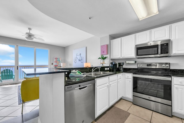 kitchen featuring a water view, appliances with stainless steel finishes, white cabinets, and kitchen peninsula