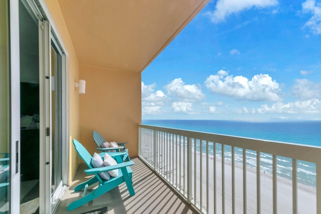 balcony featuring a water view and a view of the beach