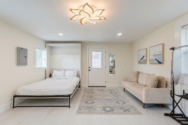 bedroom with electric panel, baseboards, wood finished floors, and recessed lighting