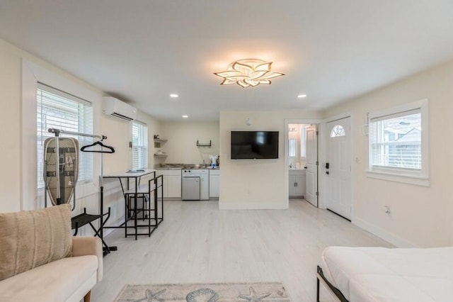 bedroom featuring light wood finished floors, a wall unit AC, recessed lighting, and baseboards