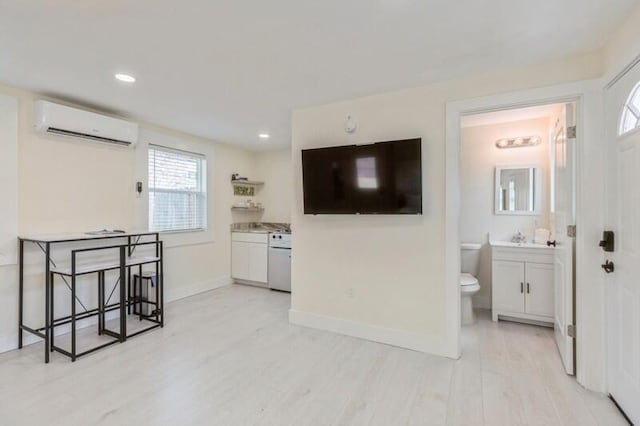 living room with light wood-style floors, recessed lighting, an AC wall unit, and baseboards