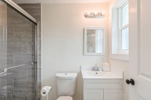 full bath with a stall shower, vanity, and toilet