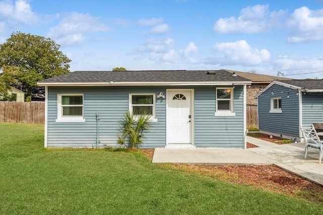 back of property featuring a yard, fence, a patio, and an outdoor structure