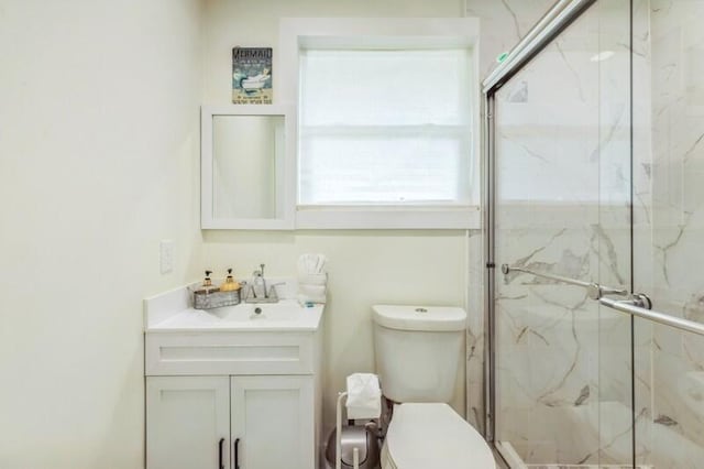 bathroom with vanity, a marble finish shower, and toilet