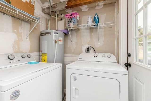 washroom with laundry area, washer and clothes dryer, and electric water heater