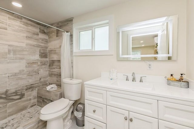 full bath with toilet, tiled shower, and vanity