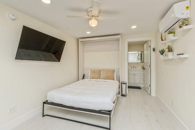 bedroom with light wood finished floors, a wall mounted AC, recessed lighting, and baseboards