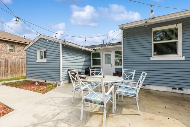 view of patio featuring outdoor dining space and fence