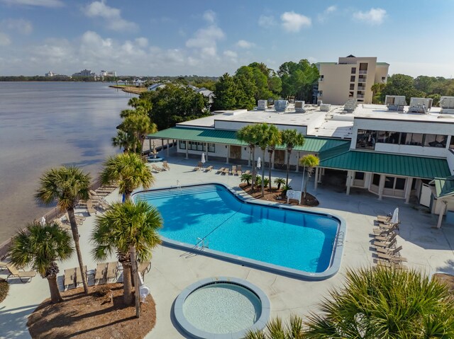 view of pool with a patio area and a water view