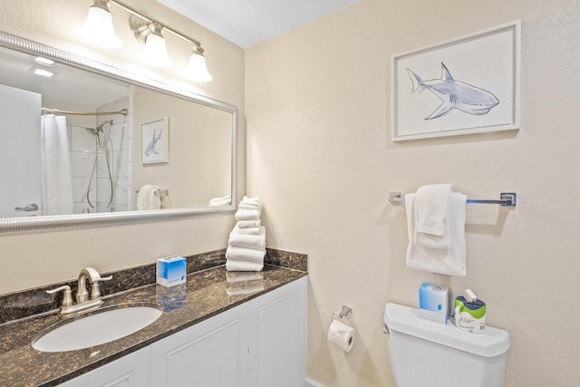 bathroom with toilet, vanity, and a shower with shower curtain