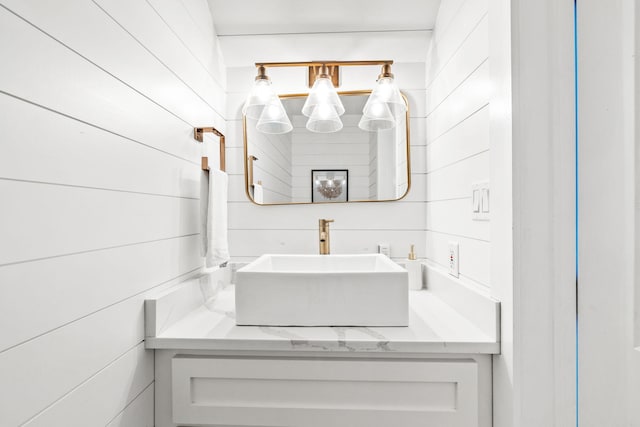 bathroom featuring vanity and wooden walls