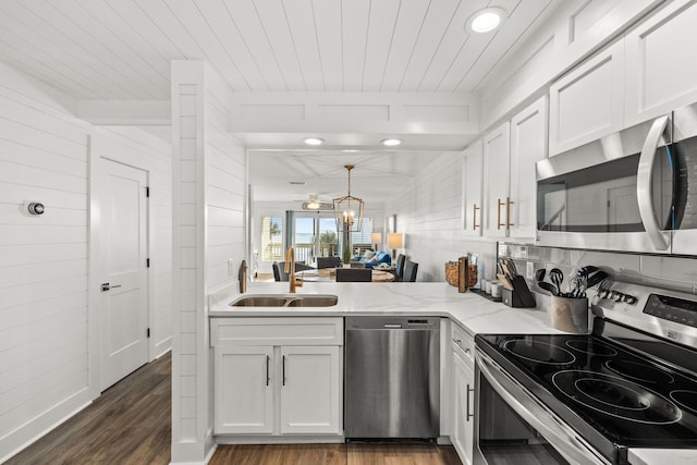 kitchen with dark hardwood / wood-style floors, white cabinetry, sink, light stone counters, and stainless steel appliances