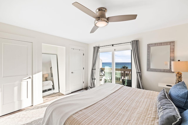 bedroom featuring a water view, ceiling fan, and access to exterior