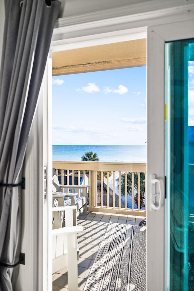 balcony featuring a view of the beach and a water view