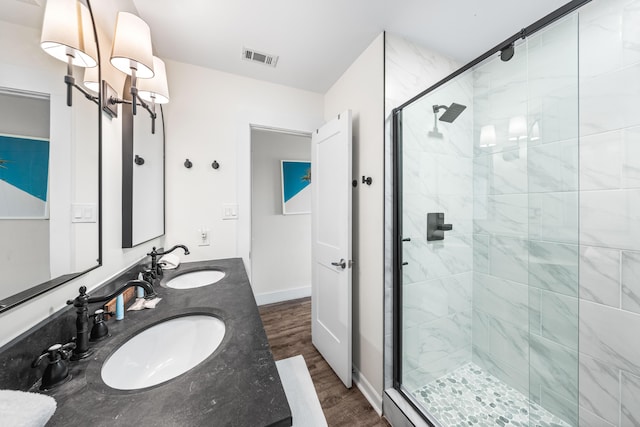 23011 Front Beach Rd Unit 65, Panama City Beach, FL 32413 - bathroom featuring a stall shower, wood finished floors, double vanity, and baseboards