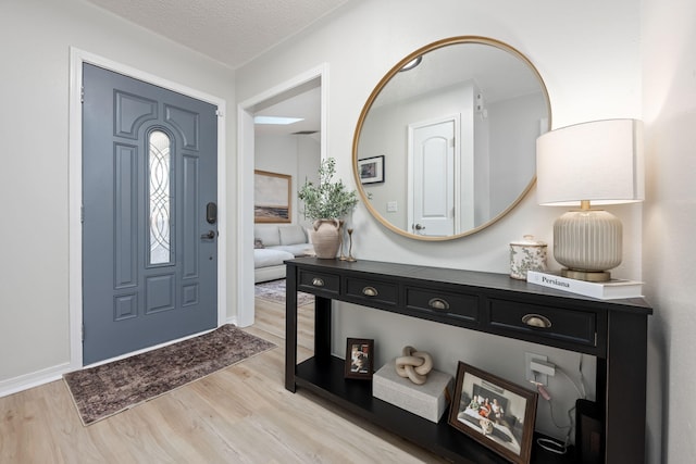 entryway with light hardwood / wood-style floors and a textured ceiling