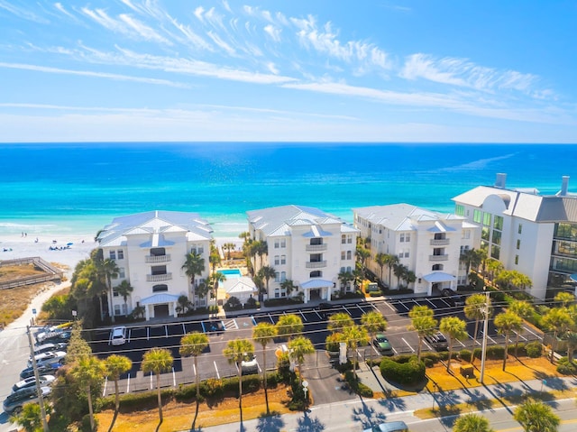 birds eye view of property with a water view and a beach view