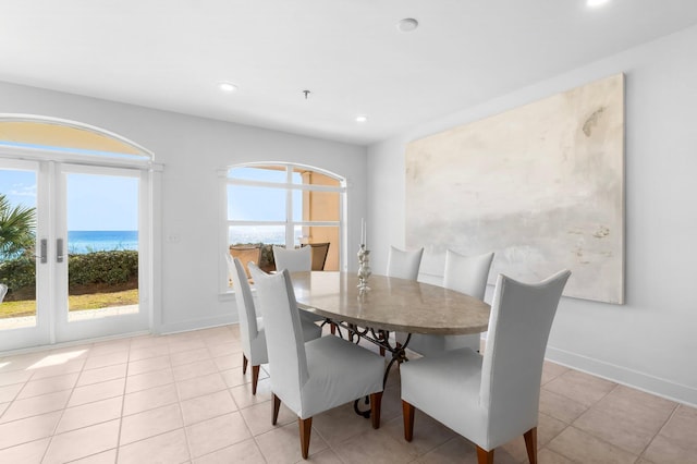 tiled dining area with a wealth of natural light and a water view