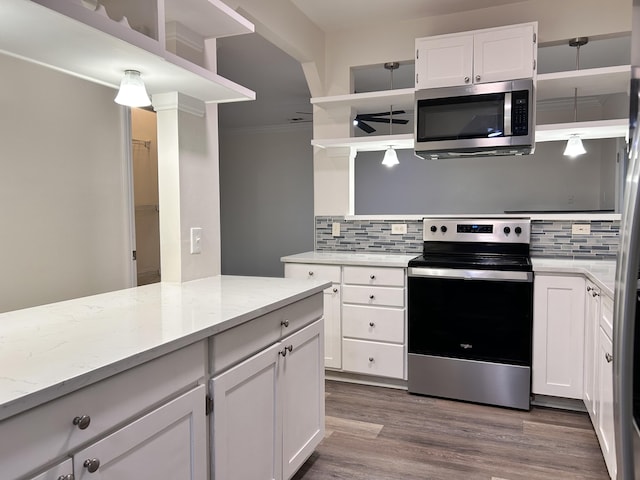 kitchen with decorative light fixtures, white cabinetry, decorative backsplash, stainless steel appliances, and crown molding