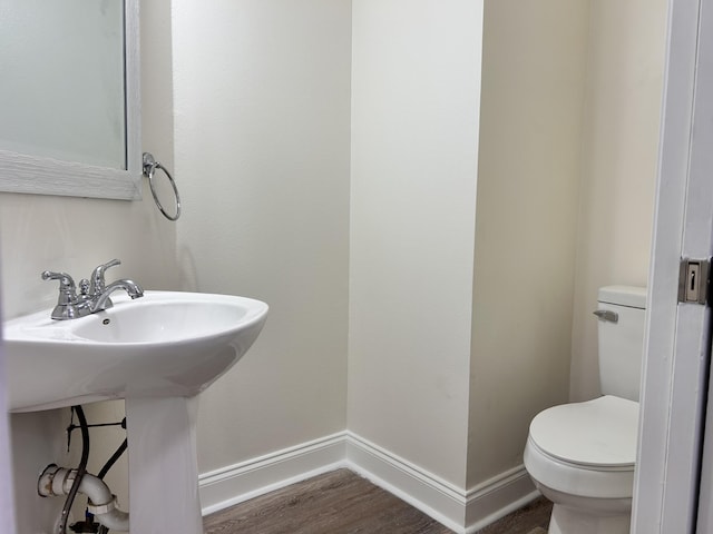 bathroom featuring hardwood / wood-style flooring and toilet