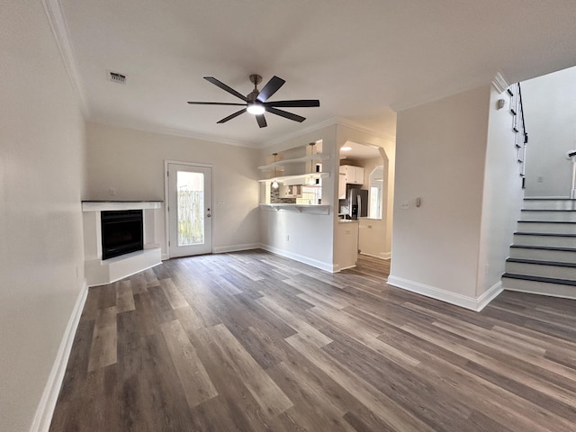 unfurnished living room with hardwood / wood-style flooring, ornamental molding, and ceiling fan