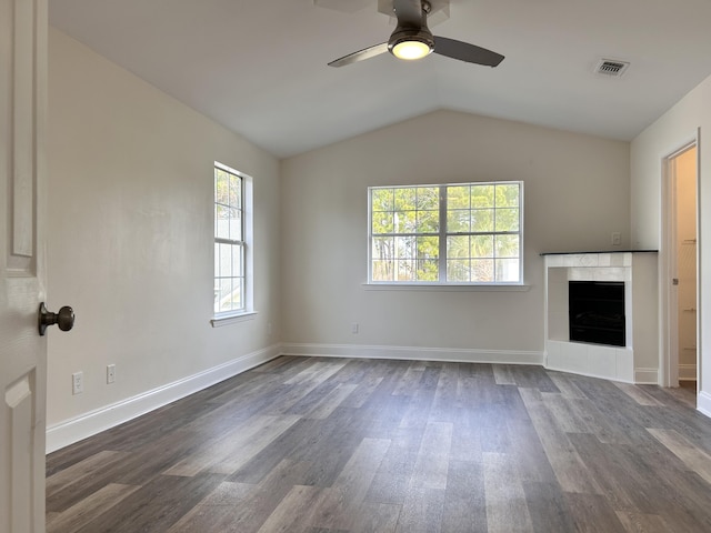 unfurnished living room featuring lofted ceiling, a fireplace, dark wood-type flooring, and ceiling fan