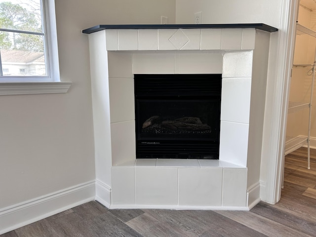 details featuring hardwood / wood-style flooring and a tiled fireplace