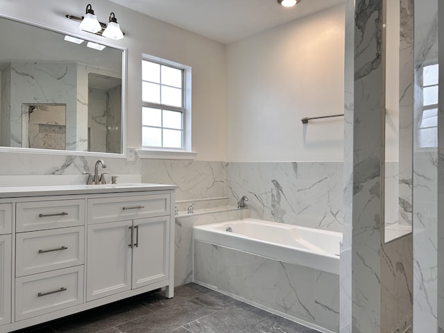 bathroom featuring a tub to relax in, vanity, and tile walls