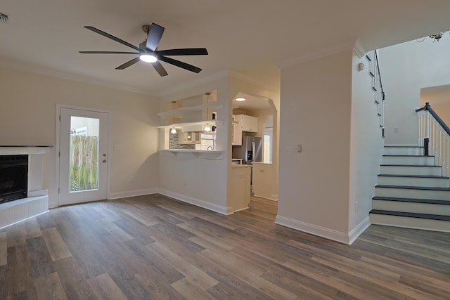 149 Legion Park Loop, Miramar Beach, FL 32550 - unfurnished living room featuring crown molding, dark wood-type flooring, a ceiling fan, stairway, and baseboards