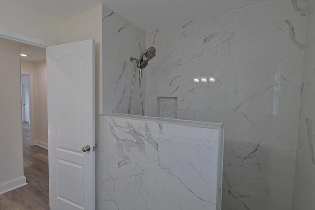 149 Legion Park Loop, Miramar Beach, FL 32550 - bathroom view of a marble finish shower, wood finished floors, and baseboards