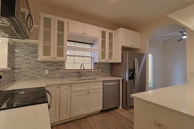 149 Legion Park Loop, Miramar Beach, FL 32550 - kitchen with a sink, stainless steel appliances, light wood finished floors, white cabinets, and decorative backsplash