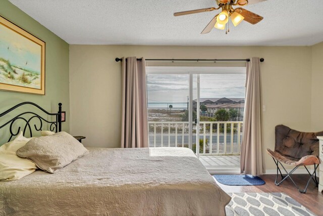 8468 Gulf Blvd # Ut-4, Navarre, FL 32566 - bedroom featuring access to exterior, hardwood / wood-style flooring, a textured ceiling, and ceiling fan