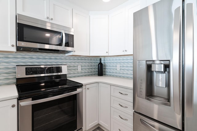 kitchen with backsplash, appliances with stainless steel finishes, and white cabinets