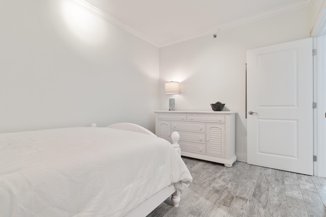 bedroom featuring ornamental molding and light hardwood / wood-style floors