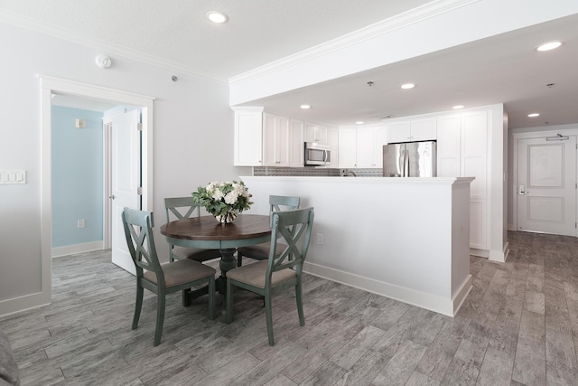 dining room featuring ornamental molding and light hardwood / wood-style floors