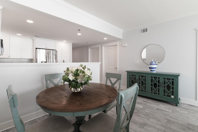 dining space with crown molding and light wood-type flooring