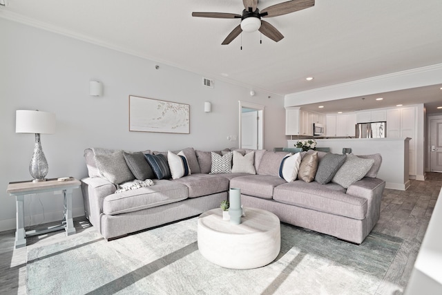 living room with ornamental molding, hardwood / wood-style floors, and ceiling fan