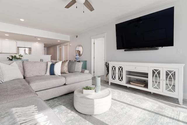 living room with ornamental molding and ceiling fan