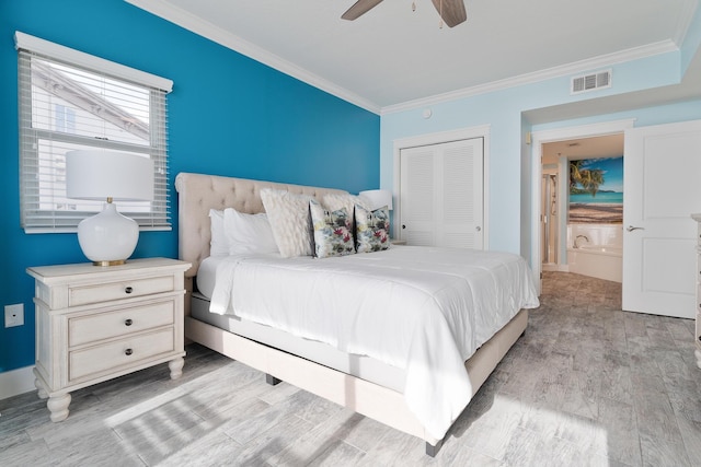 bedroom with crown molding, light hardwood / wood-style flooring, a closet, and ceiling fan