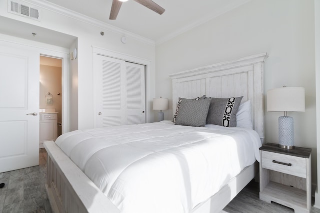 bedroom with ornamental molding, dark hardwood / wood-style floors, ceiling fan, and a closet