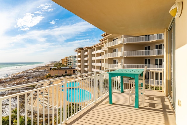 balcony with a water view and a beach view