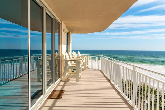 balcony with a water view and a beach view